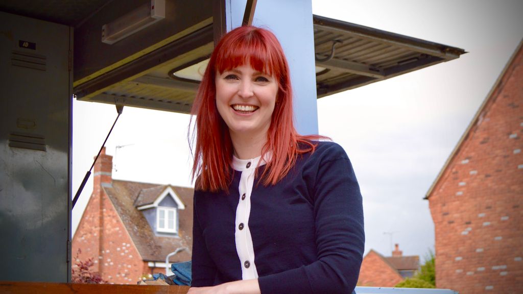 Woman with red hair standing in front of the restoration van