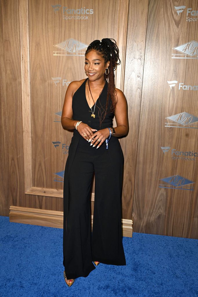 Tiffany Haddish on blue carpet in black jumpsuit