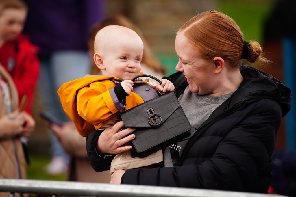 Lucy Williams, from Aberfan, holds her son Daniel Williams, one, as plays with the handbag of the Princess of Wales