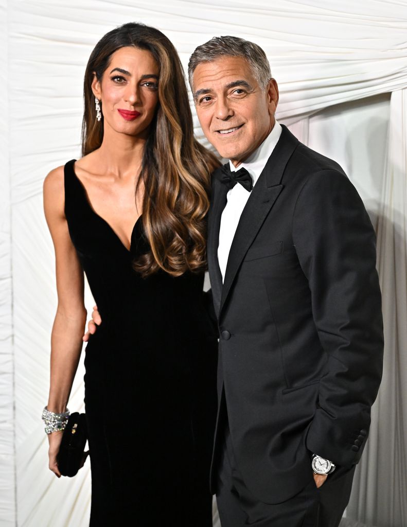 Woman with long brunette hair standing with man in suit 