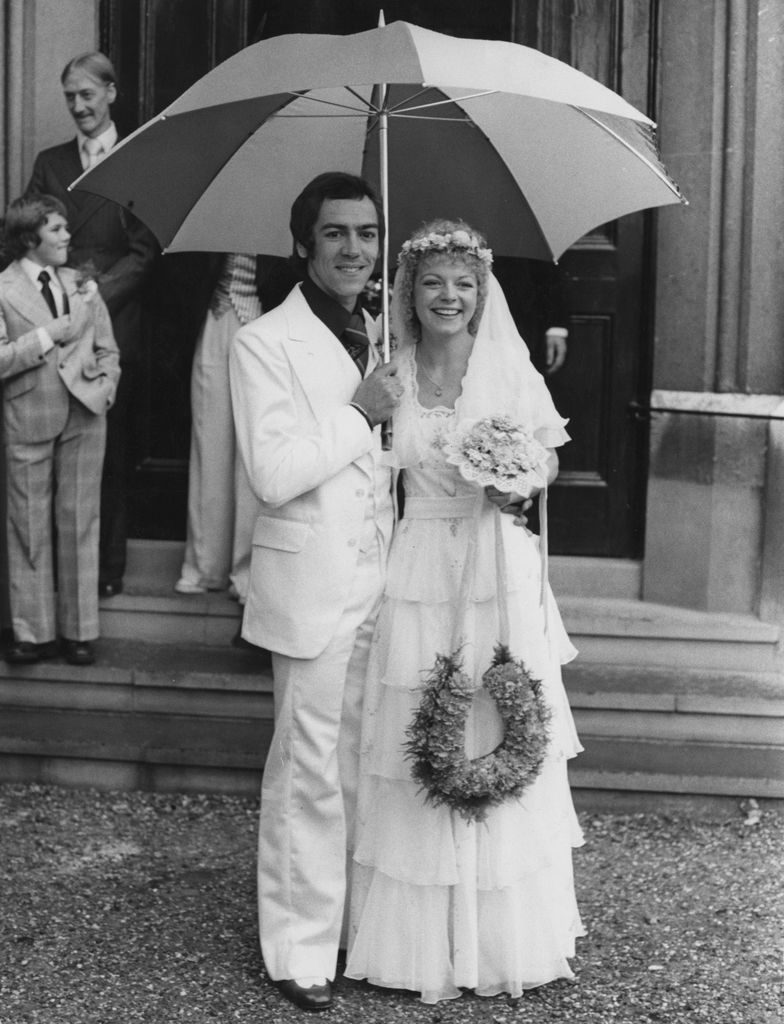 Robert Lindsay and Cheryl Hall stand under an umbrella on their wedding day