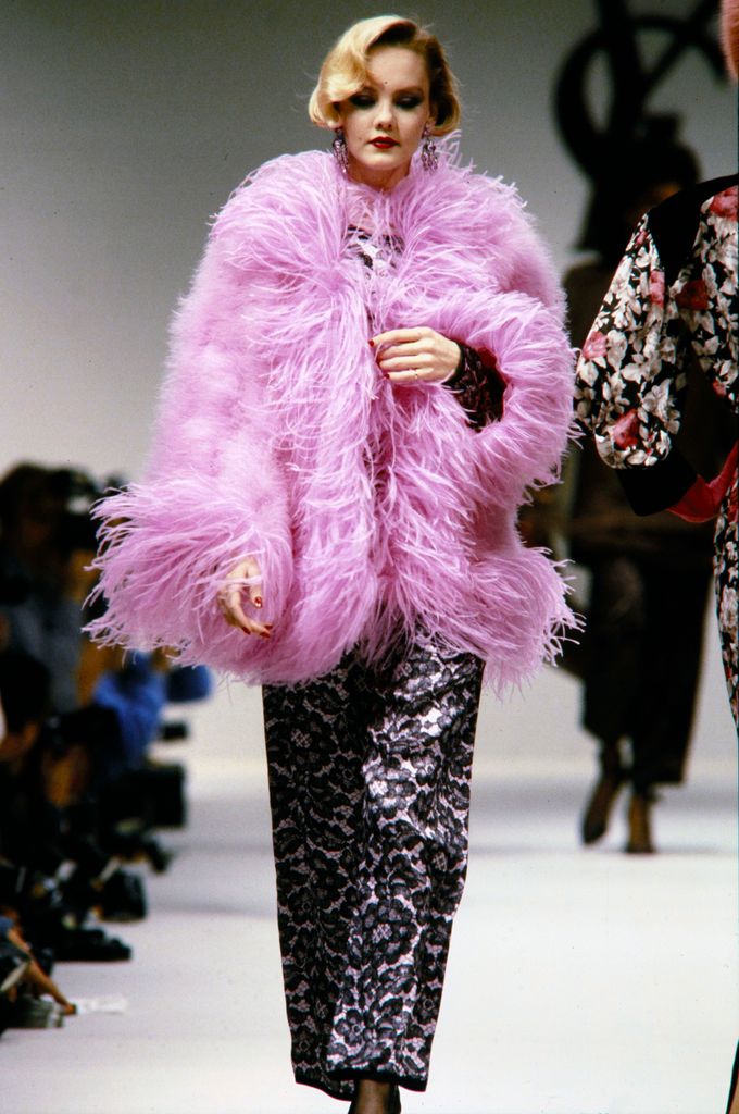 Un mannequin défile lors du défilé prêt-à-porter Yves Saint Laurent automne 1984 en manteau rose moelleux
