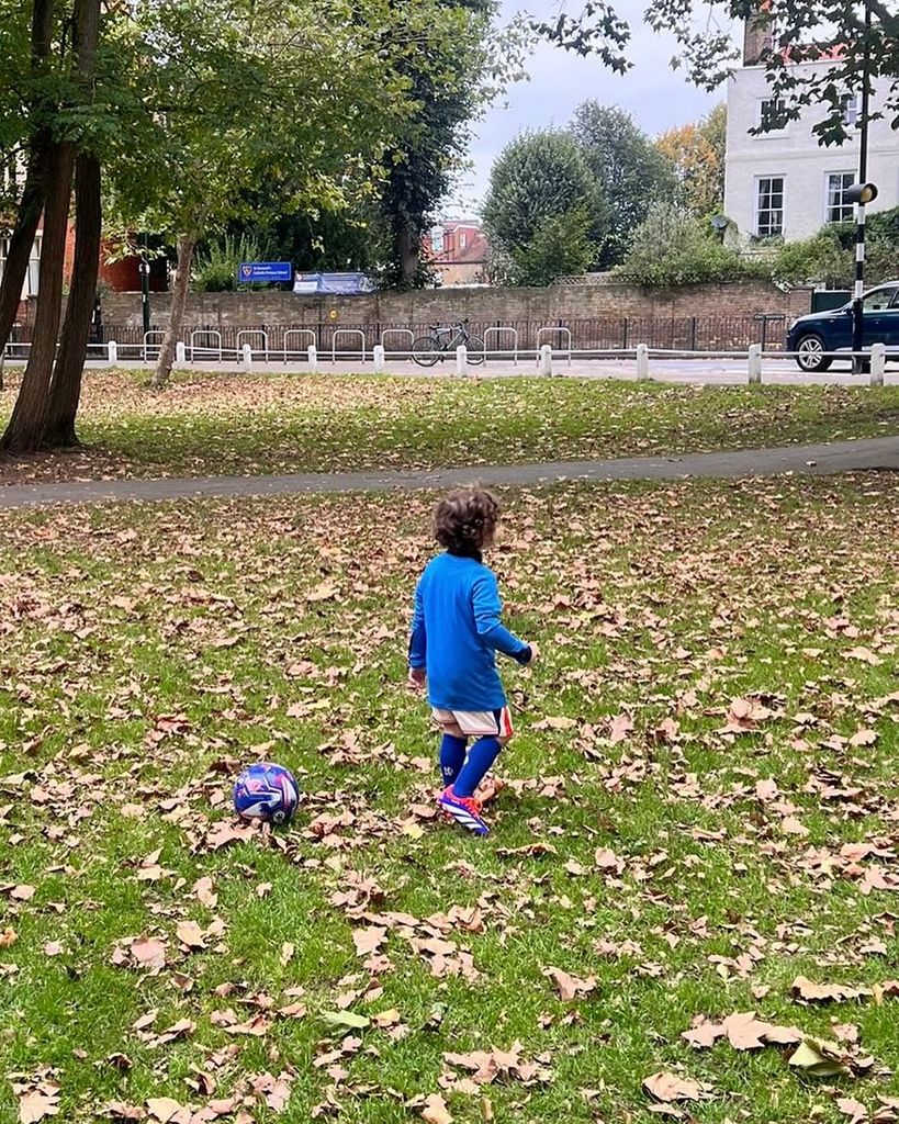 small boy with football on grass