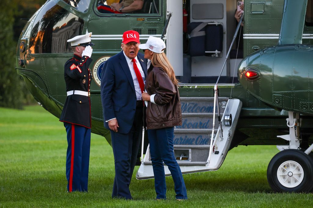 President Donald Trump and first lady Melania Trump talk after disembarking Marine One on the South Lawn of the White House 