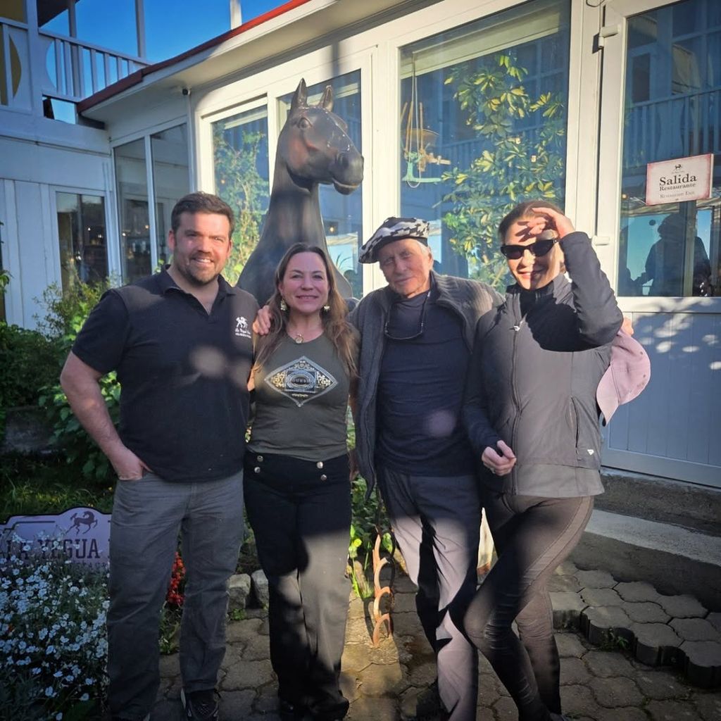 Catherine Zeta-Jones and Michael Douglas pose for a photo with the owners of a hotel in Chile ahead of their trip to Antarctica