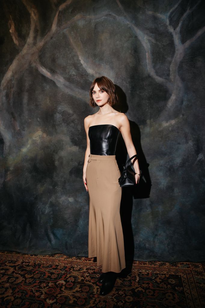 Emilia Jones porte un haut bustier en cuir et une jupe longue beige