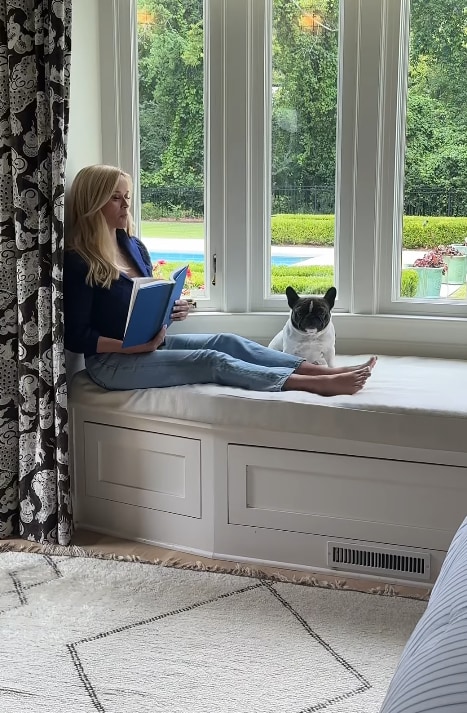 Reese Witherspoon sits in a gorgeous reading nook