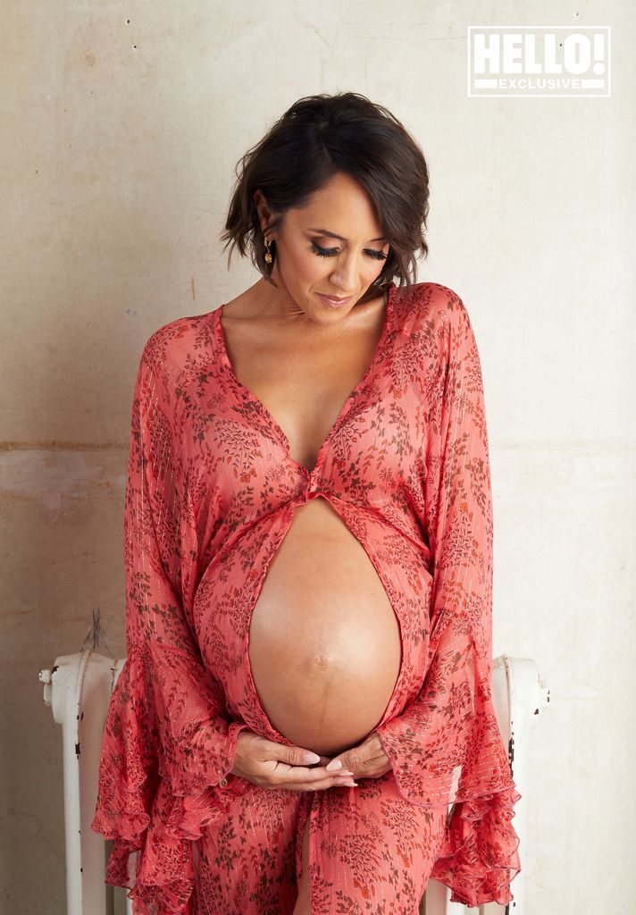 Janette Manrara cradling bare baby bump in pink kimono