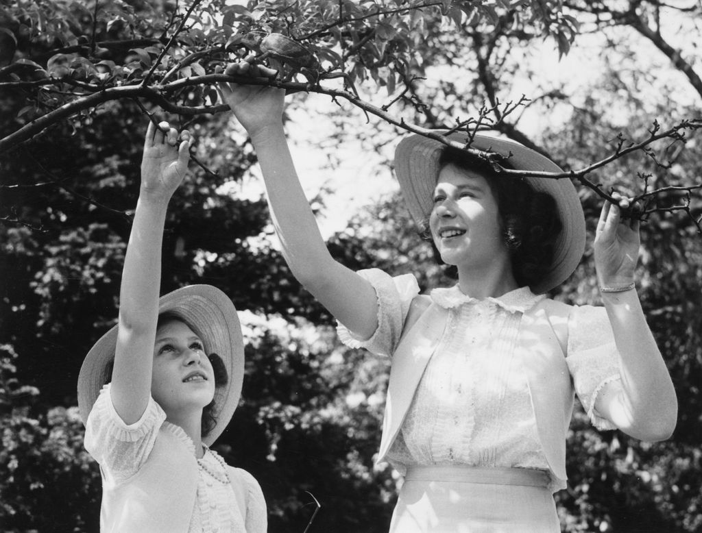 Princess Elizabeth and Princess Margaret playing with their pet chameleon in the grounds of Windsor Castle