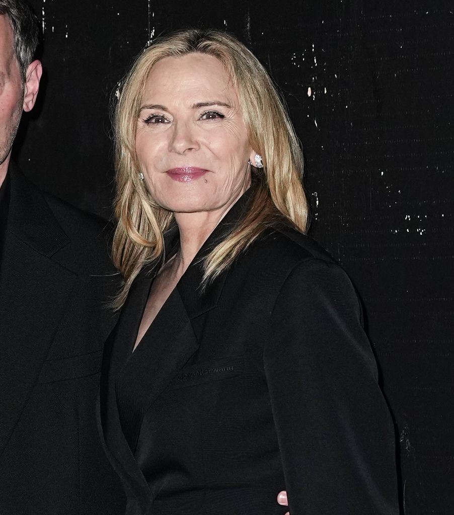 Kim Cattrall smiling in a black blazer