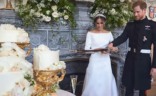Prince Harry and Meghan Markle cutting their wedding cake with a sword