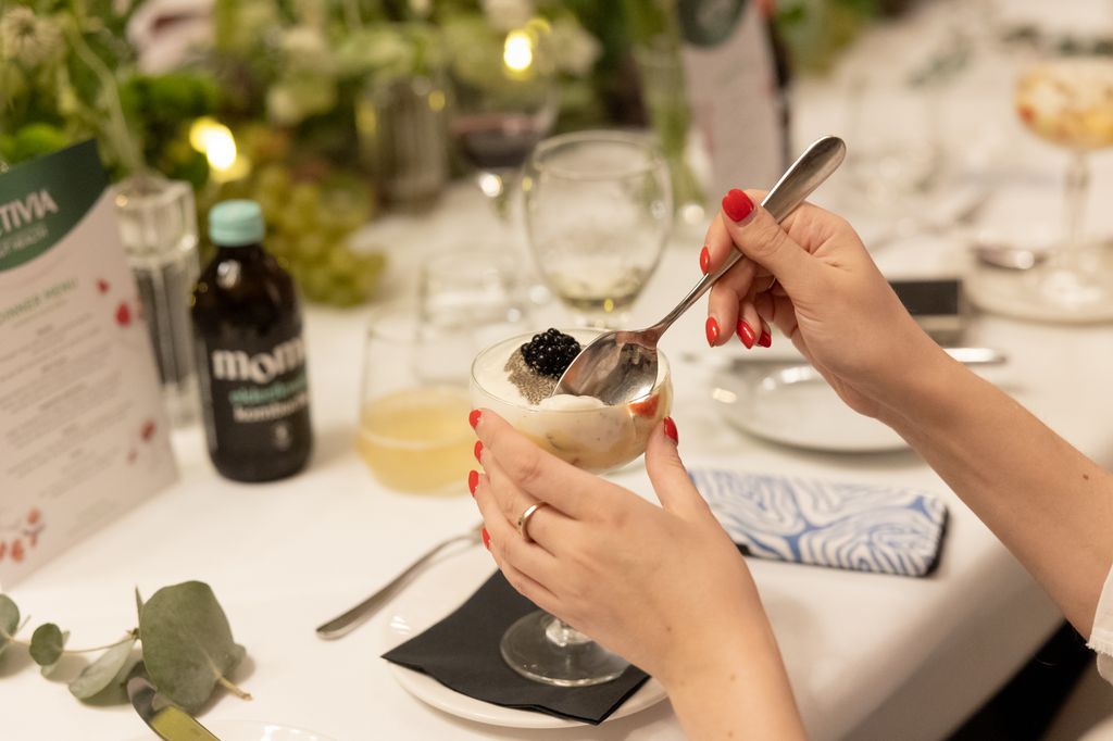 Woman with red nails spoons trifle out of glass