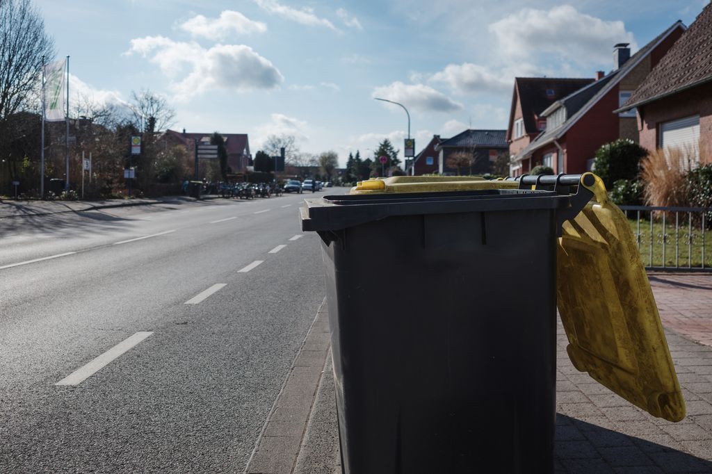 A row of black garbage bins