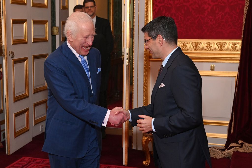 King Charles shaking hands with a man in a suit