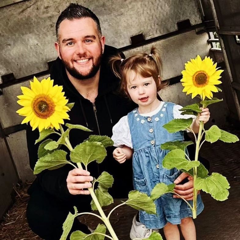 Eamonn's son Declan holding sunflower with daughter Emilia