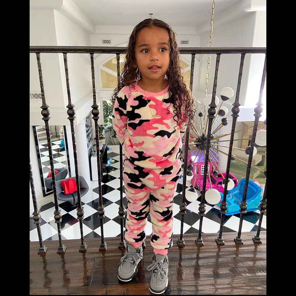 Dream Kardashian standing on staircase balcony at home