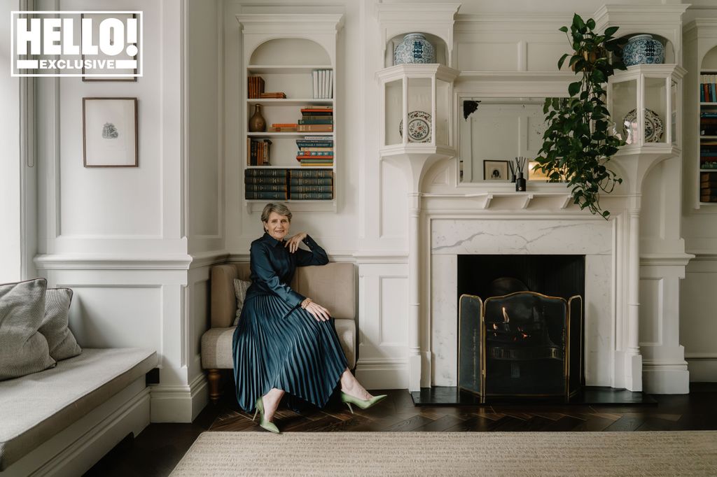 A woman wearing a green dress sitting down in a living room