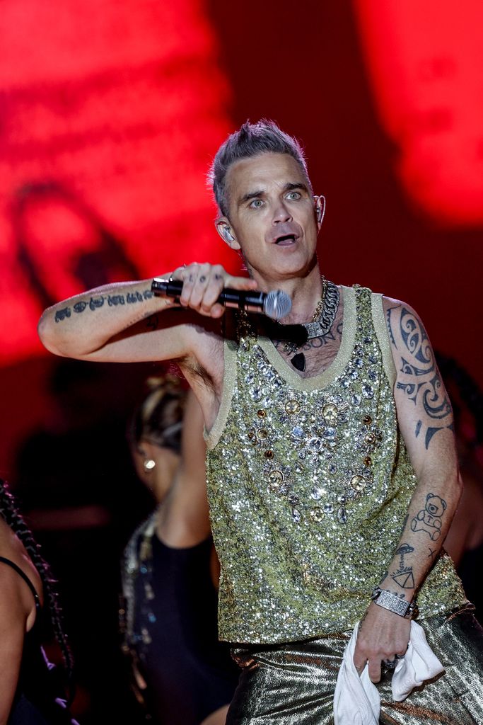 Robbie Williams in glittery, sleeveless shirt