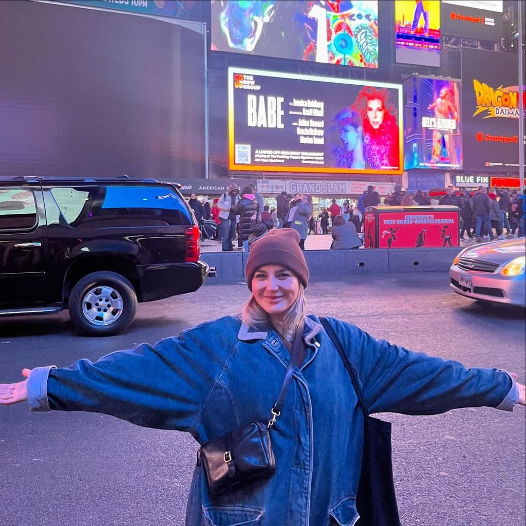 Gracie McGraw stands in front of the opening sign for "Babe" in Times Square, photo shared on Instagram