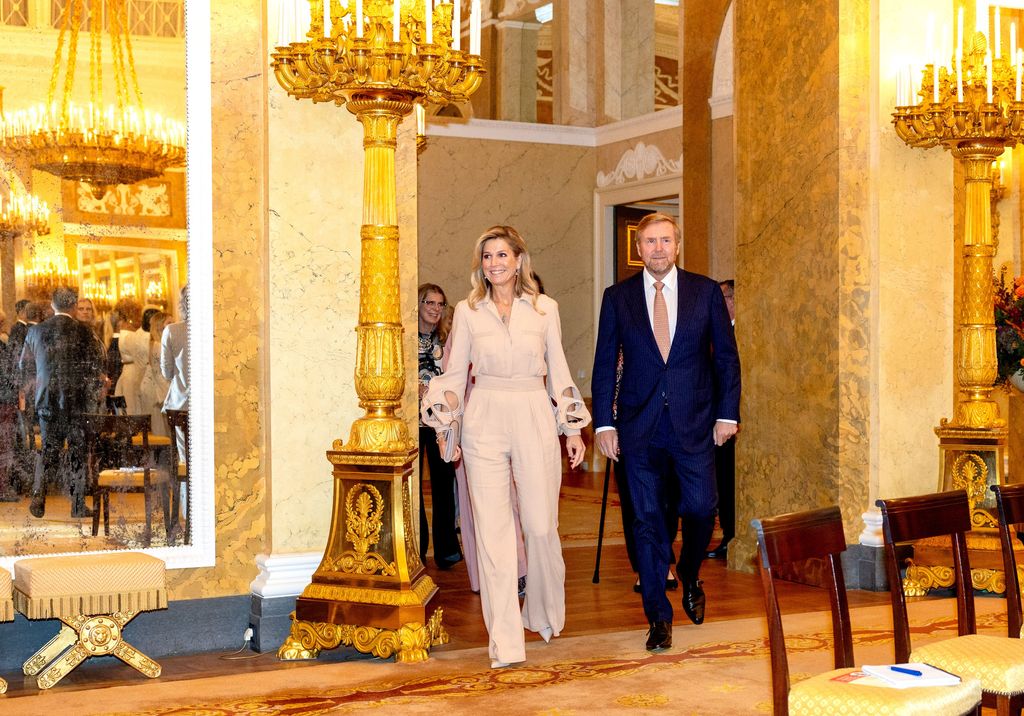 Queen Maxima in nude jumpsuit and king Willem-Alexander enter palace room
