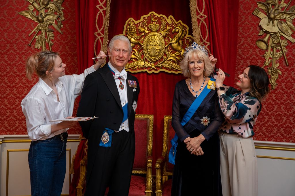 Two artists working on waxwork figures of King Charles and Queen Consort Camilla