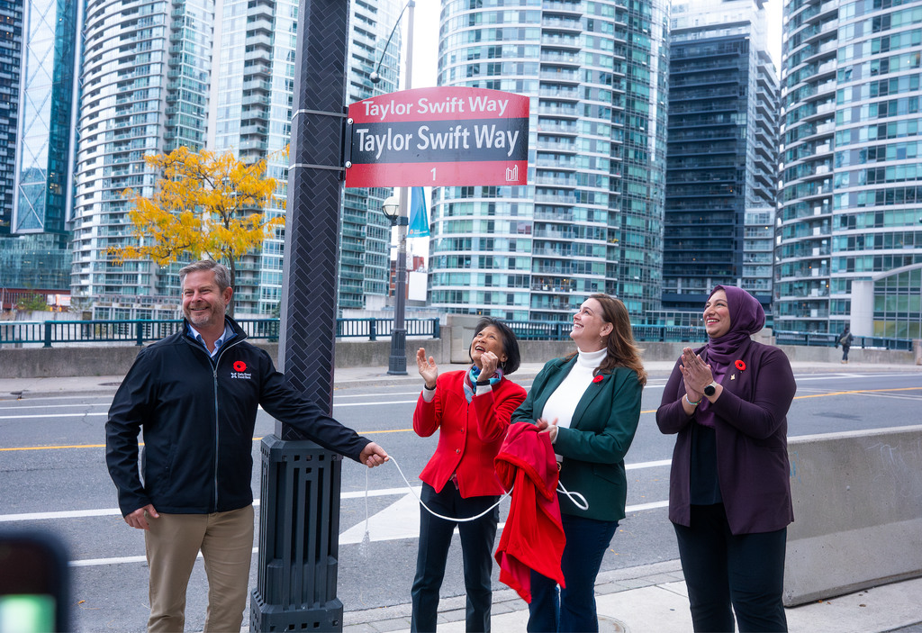 The Daily Bread’s Neil Hetherington, Toronto Mayor Olivia Chow and Deputy Mayors Jennifer McKelvie and Ausma Malik prepare to welcome the world, unveiling a new street sign honouring the pop star.