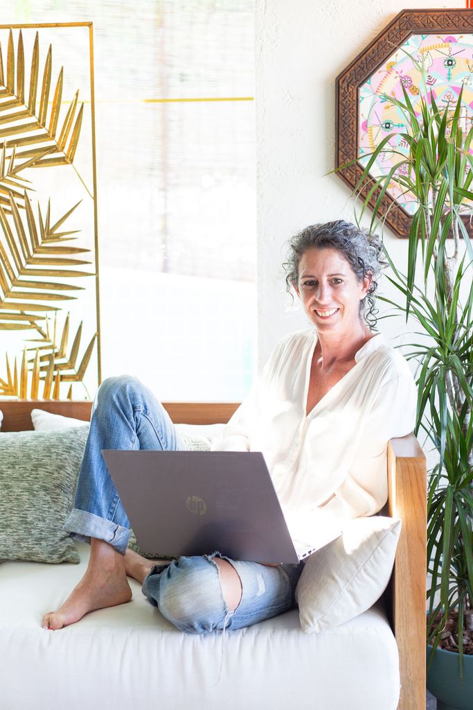Woman on her laptop next to a plant