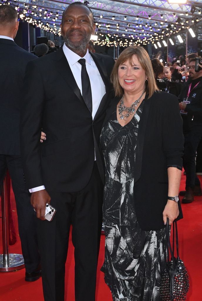 Lenny Henry in a black suit with Lisa Makin on the red carpet