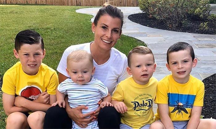 Coleen Rooney lächelt mit ihren vier Söhnen in gelben Oberteilen