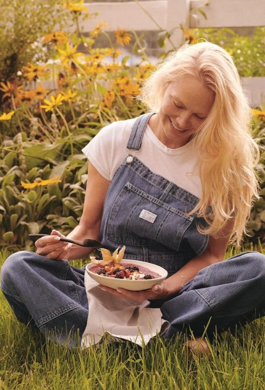Gwyenth sat in dungarees eating a breakfast bowl 