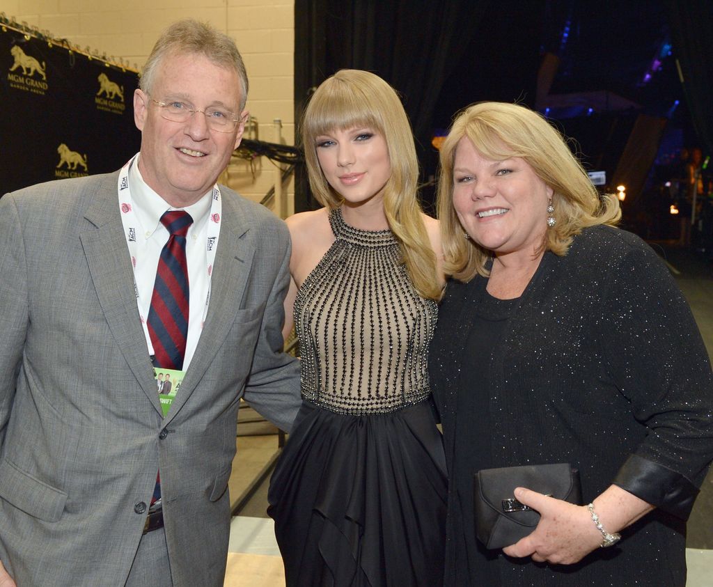 Taylor Swift smiling with her parents Scott and Andrea Swift