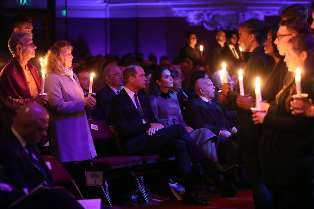 William and Kate seated in front of people holding candles