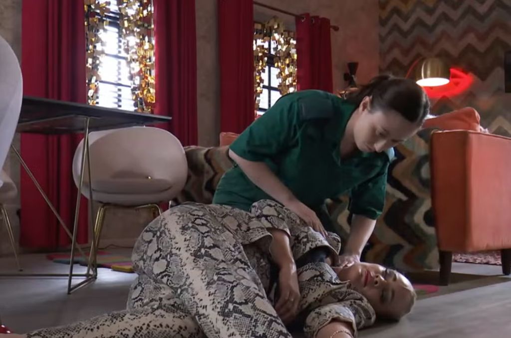 Courtney Cash as a paramedic tending to Tamara Wall as Grace Black in Hollyoaks