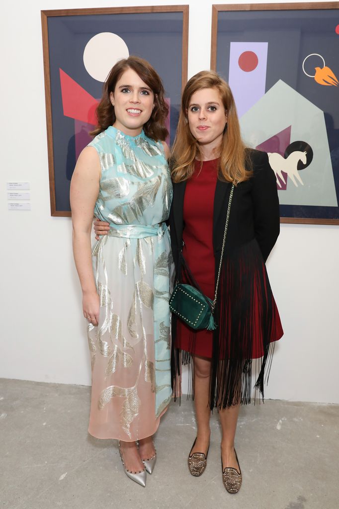 Princess Eugenie and Princess Beatrice pose by artwork