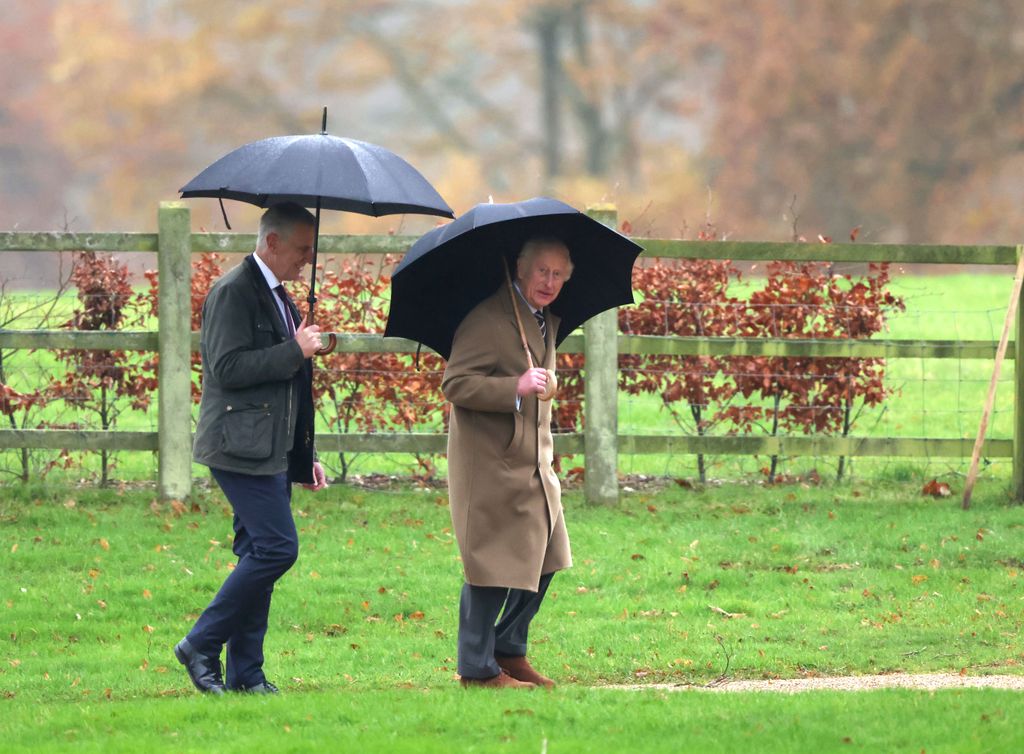 king charles walking with umbrella 