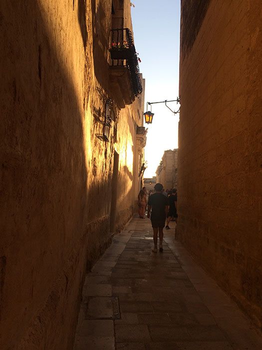 Jack walking down typical street in Mdina at dusk