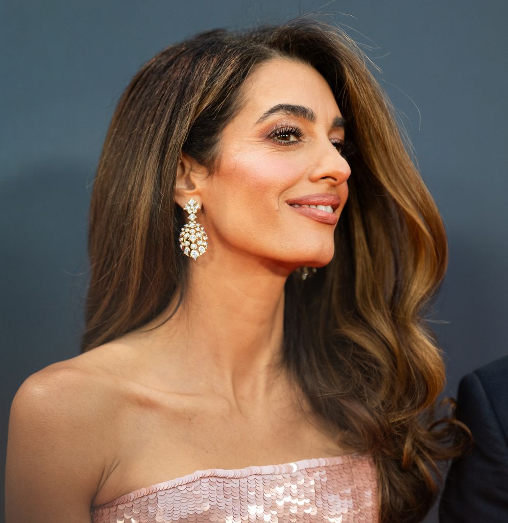 Amal Clooney looking to right in strapless pink dress