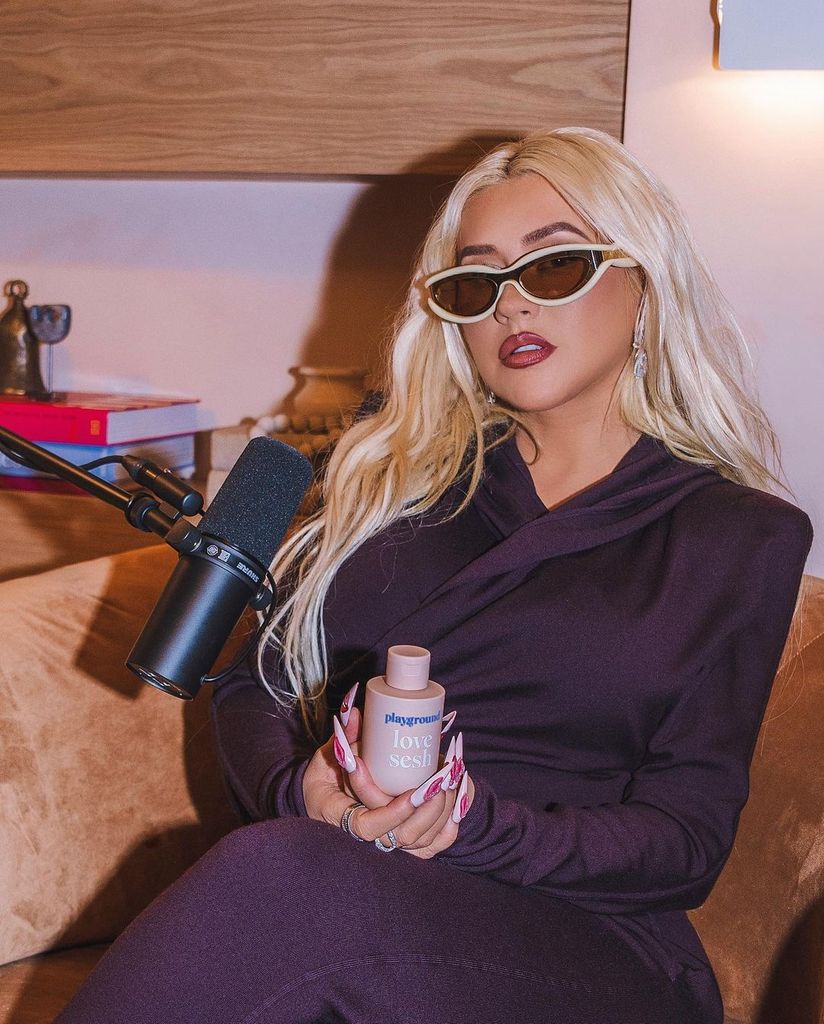 Christina Aguilera posing with a bottle of Playground lubricant