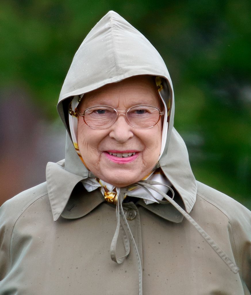 Queen smiling in raincoat