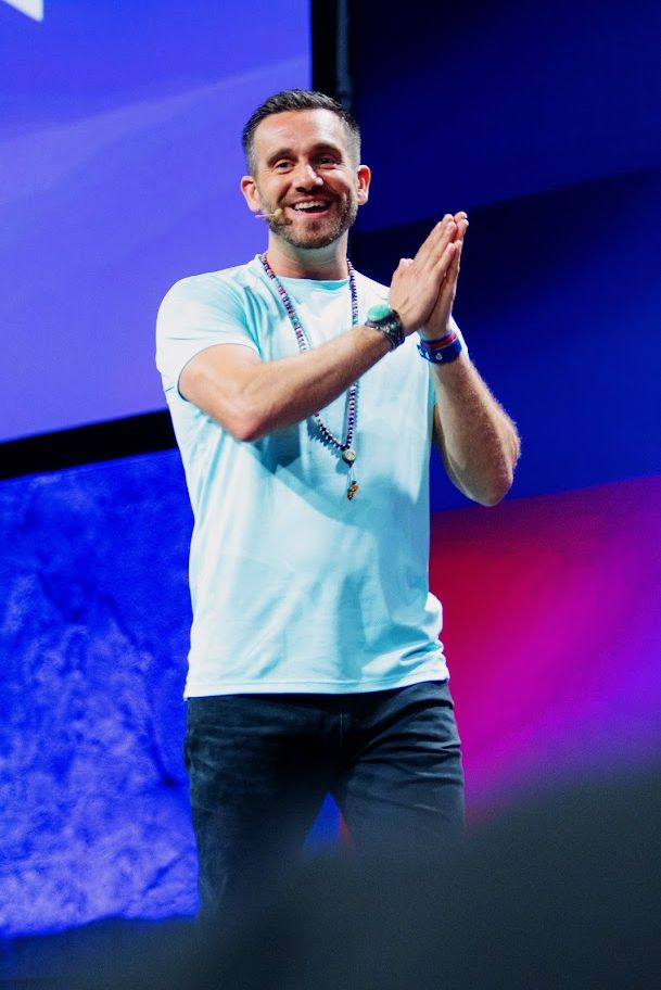 Charlie claps as he delivers a speech on stage