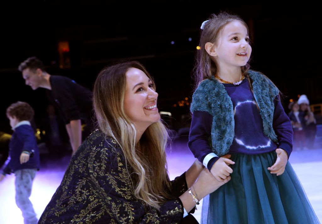 Haylie Duff s'accroupit à côté de sa fille et lui tient la main.