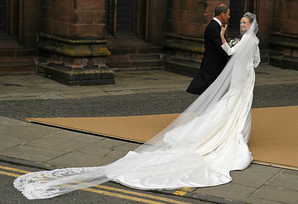 The bride's veil blew in the wind, prompting gasps from the crowd, as she entered the cathedral

