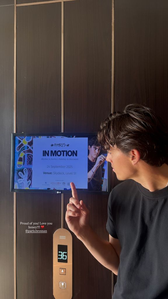 Photo of Paris Brosnan wearing black t-shirt in elevator