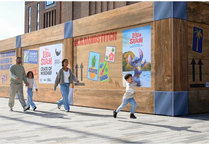 A family walking outside a crate with Lilo & Stitch on it