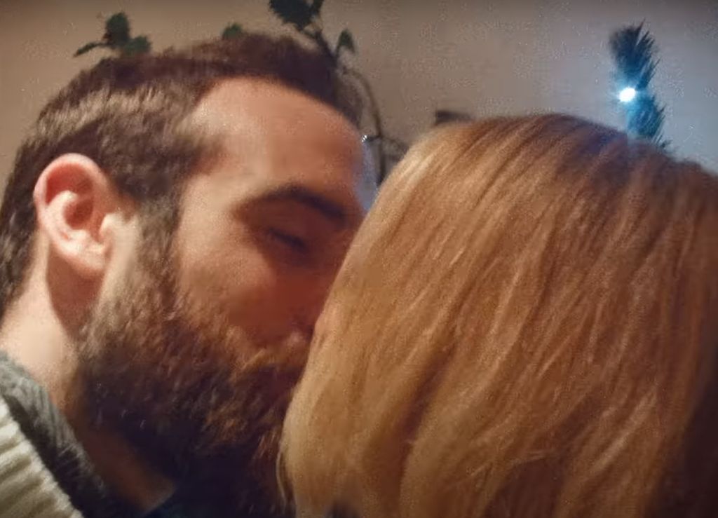 Joshua Sasse and Kylie Minogue kissing underneath the mistletoe