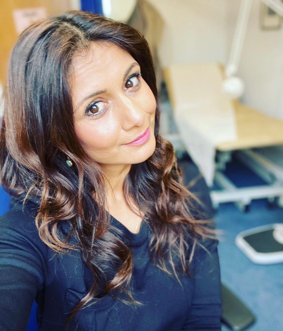 Dr. Anisha Patel posing for a selfie in pink lipstick