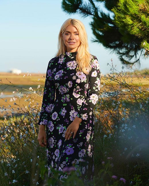 holly willoughby posing in purple floral dress in field