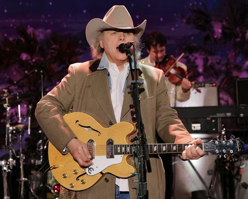 Dwight Yoakam singing on stage with his guitar