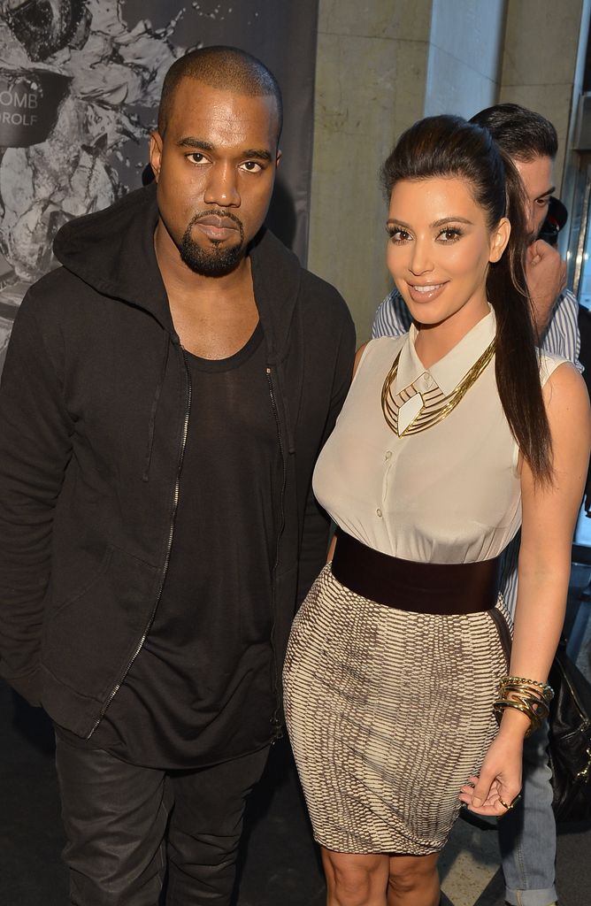 Kim Kardashian and Kanye West posing in a full length photo