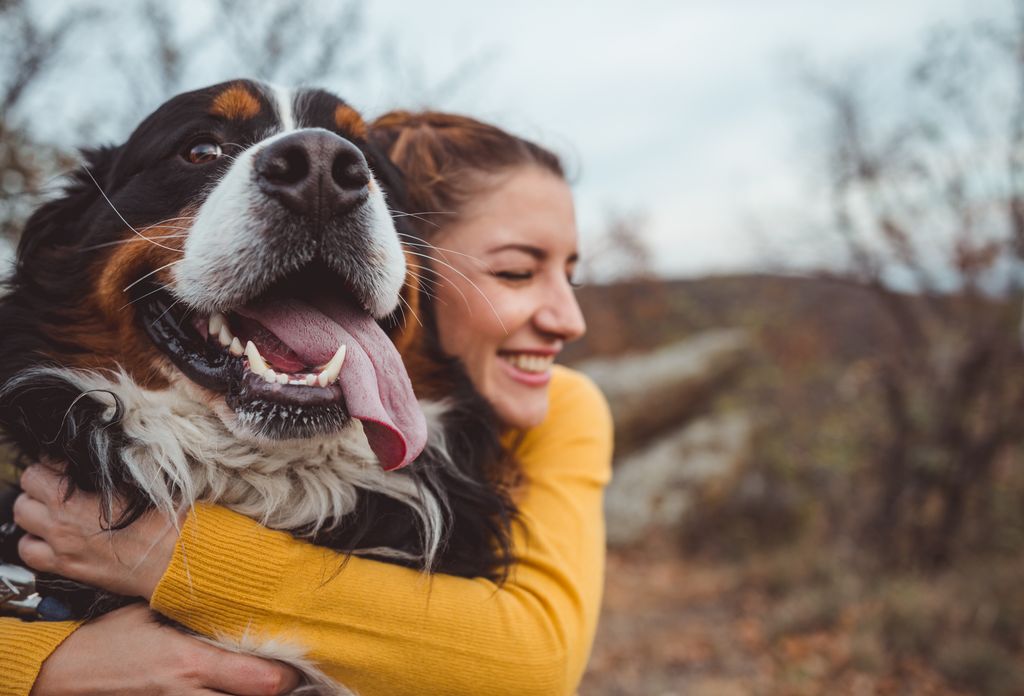 woman hugging large dog.